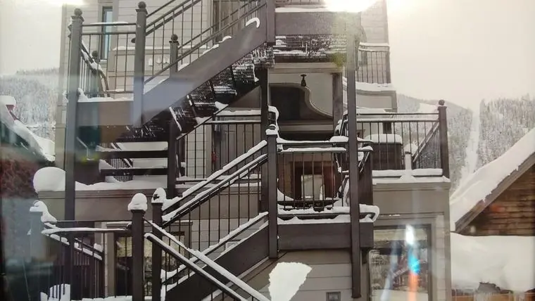 Exterior steel stairs and railings on a snowy mountain building