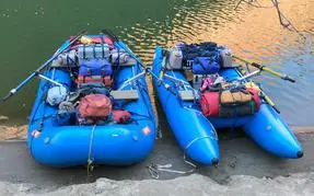 Two blue rafts with Welfelt frames, loaded with gear